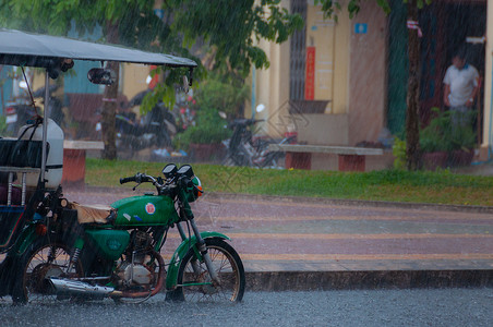 Tuktuk 在贡布的雨季风中进行自动循环运输出租车天气下雨街道摩托车摩托人力车背景