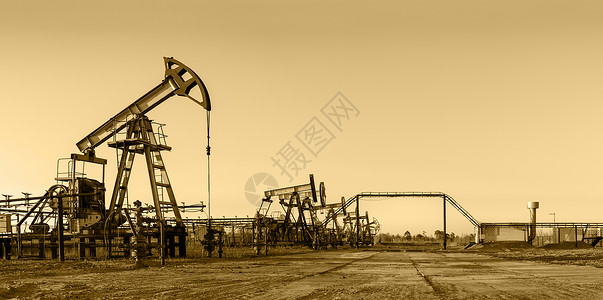 工业用地油田上的油泵钻机棕褐色管道工业石油机械千斤顶钻孔全景调子背景