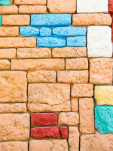 彩色石头的墙壁棕色黄色红色石墙白色蓝色框架水泥背景图片