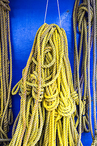 黄船绳安全领带电缆力量绳索蓝色海洋细绳黄色褪色背景图片