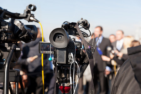 记者招待会 用摄像头拍摄一个事件发布会电视录影机摄像师摄影师麦克风广播居住新闻技术背景图片
