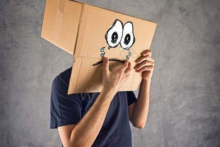 纸板猫头鹰头上戴纸箱和面部表情悲伤的人纸板哭泣符号创造力呜咽悲哀情绪男性情感男人背景