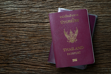 泰籍护照游客木桌桌子木头旅行社手提箱背景背景图片