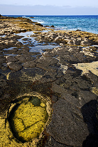 在西班牙兰萨罗特岩石岩石 火山壁的海岸线和背景图片