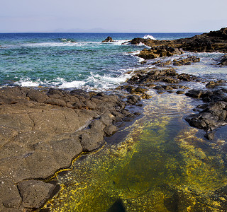 岩藻多糖在西班牙兰萨罗特的寒冷海岸线 岩石岩云云背景