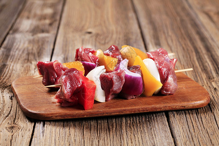 Shish 烤肉串砧板烤串鹿肉辣椒木头牛肉洋葱红肉橙子食物背景图片