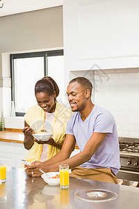 早餐时用药片的年轻夫妇住所夫妻感情男朋友快乐家庭女士平板电脑厨房背景图片