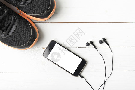 耳机鞋素材运动鞋和电话耳机手机运动技术白色毛巾手表木头音乐健身房背景