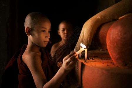 在修道院用烛光祷告的佛教新教徒高清图片