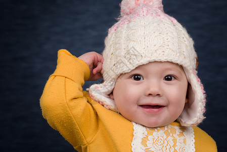 带冬帽的女婴婴儿针织帽幸福女孩们衣服白色孩子孩子们女孩寒冷背景图片