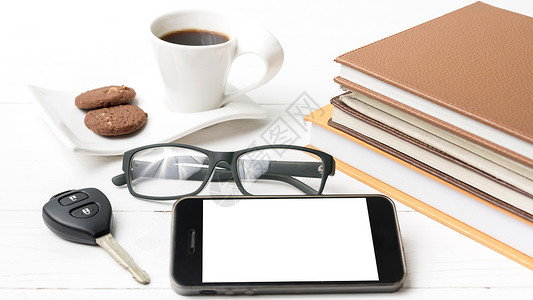 咖啡杯加饼干 手机 汽车钥匙 眼镜和书本笔记本细胞办公室电话咖啡工作杯子钥匙桌子网络背景图片