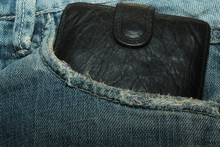 口袋中的钱包物品蓝色黑色皮革艺术牛仔裤背景图片