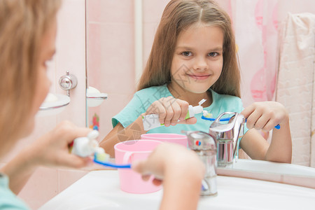 6岁女孩从牙刷上一根管子挤牙膏背景图片