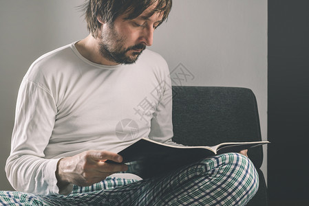 男人清晨读杂志 穿着睡衣的男子背景图片