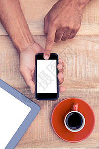 使用智能电话的人 按咖啡和桌上的平板裁剪药片技术饮料休闲短信手机沟通活动屏幕背景图片