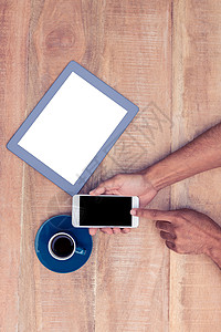 男人用智能电话 咖啡和桌上的平板电脑背景图片
