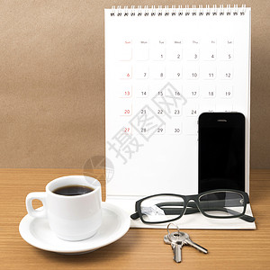 咖啡 电话 眼镜 日历和钥匙白色工作木头商业办公室桌子背景图片