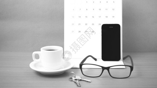 咖啡 电话 眼镜 日历和钥匙办公室桌子木头工作商业白色背景图片