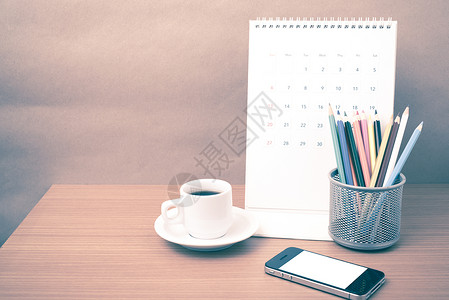 咖啡 电话 日历和彩色铅笔杯子白色木头桌子文档工作记事本笔记职场办公室背景图片
