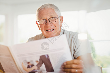 重点突出的老年男子阅读报纸客厅闲暇椅子流金家庭家庭生活男性桌子男人退休背景图片