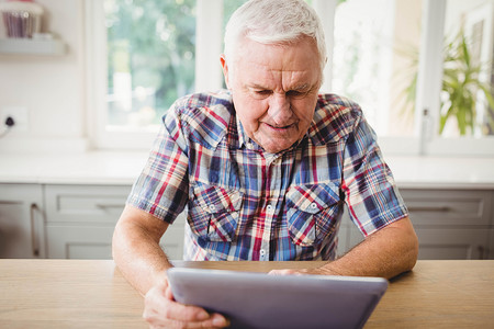 高级男子使用数字平板电脑老年互联网闲暇电子房子住所休闲技术快乐老年人背景图片