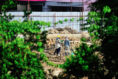 人们在太阳光下醒来中心活动城市起重机建筑工人地下室检查天空梯子背景图片