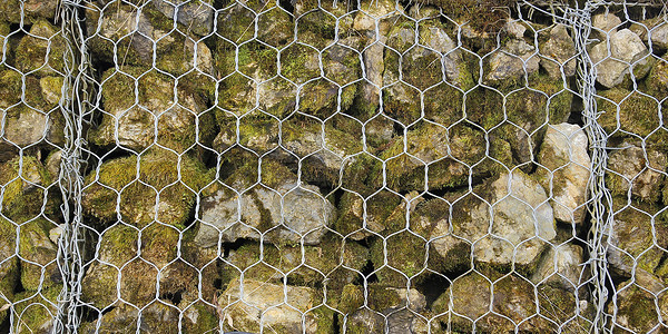 ps网墙素材在Fenc后面用小块岩石建造的屏障特写框架地面阳光网格巨石材料技术石头石墙金属背景