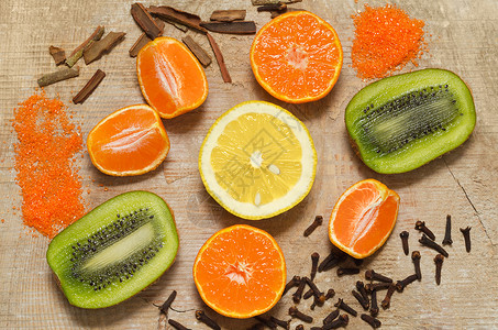 水果和香料的切片落在旧板上背景橙子肉桂黄色绿色物品木板平均数柠檬棕色背景图片