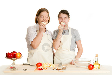 外祖母和孙孙女拿着苹果片子白色食物孙子女性微笑祖父母成人烹饪家庭孙女背景图片