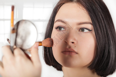 女孩做化妆刷子女性黑发眼影沙龙肤色睫毛眼睛睫毛膏女士背景图片