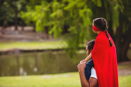 穿着超级超级英雄服装的女孩坐在父亲肩上喜悦超级英雄女儿面具娱乐斗篷混血乐趣孩子英雄背景图片