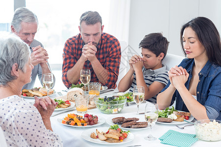 家人在吃饭前一起祈祷祖母椅子玻璃男生童年家居家庭住所男人餐桌背景