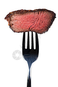 在叉子上烤牛排的一块块牛肉白色食物金属银器味道营养刀具棕色背景图片