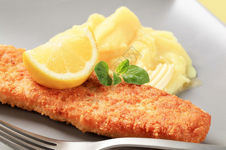 带马铃薯泥的炸鱼柠檬油炸白鱼鳕鱼盘子面包屑鱼片食物黄油午餐图片