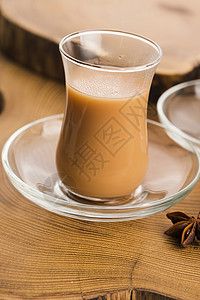 马萨拉沙伊牛奶叶子香菜黑色小豆蔻玻璃杯草药茶杯粉红色时间背景图片