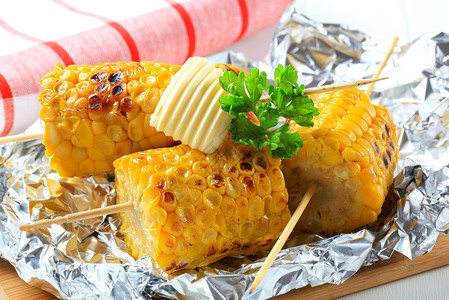 牙状粽子谷状玉米香菜小吃午餐伴奏棒子食物库存铝箔黄油锡纸背景