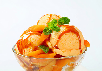 冰霜圣代焦糖奶糖轿跑车玻璃配料勺子橙子甜点食物水果背景图片