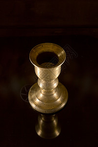 老黄铜烛台桌子烧伤古董青铜燃烧持有者反射烛光背景图片