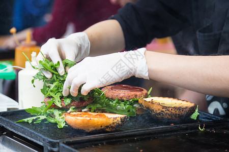 开放式三明治牛肉汉堡准备在食物摊位上吃盘子餐饮敷料餐厅厨房午餐沙拉小贩手套街道背景