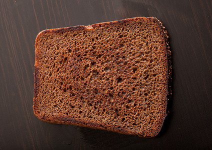 木制桌上的烤奶瓜黑麦面包鸟瞰图油炸条纹炙烤早餐生产食物面包黑色桌子背景图片