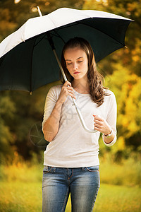 带雨伞的年轻妇女成人公园孤独女性季节背景图片