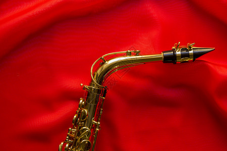 金色萨克斯管金子光泽材料折痕音乐爵士乐艺术床单丝绸波浪状背景图片