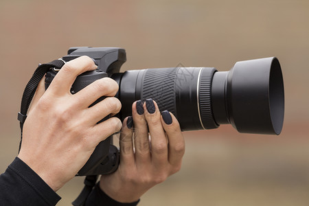 女孩手中的摄像机三脚架指甲运动女士娱乐制作艺术镜片城市宏观背景图片