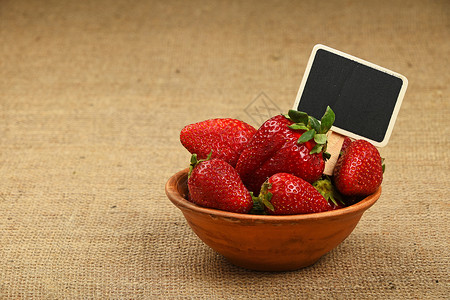 水果标志图片碗中的草莓和画布上的价格标志食物水果标签陶瓷黑板农业麻布粉笔盘子黑色背景