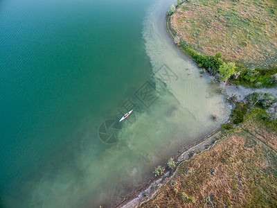 湖中独木舟和空中观察水库航拍天线白色男性桨手皮艇背景