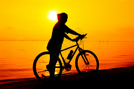 骑自行车者在海边享受景色的轮廓 门外背景图片