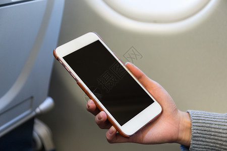 女性在飞机内使用手机背景图片
