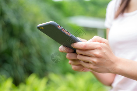 女性使用移动电话的情况手机阅读植物细胞冲浪短信游戏女孩绿色女士背景图片