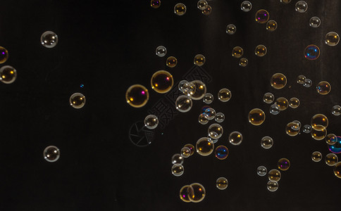 漂亮的飞行气泡在 studi液体肥皂反射黑色泡沫圆圈圆形艺术背景图片