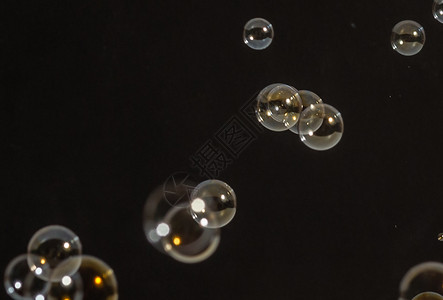 漂亮的飞行气泡在 studi泡沫圆圈艺术反射肥皂黑色圆形液体背景图片